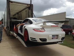 Image: Porsche being loaded into a truck for transport.