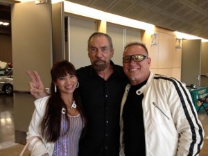 John Paul Dejoria standing with New World Auto Transport owners Steve and Daisy Wells.