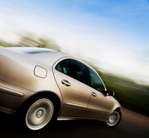 Picture of a silver car driving on the road.