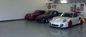 A picture of three expensive cars in auto storage