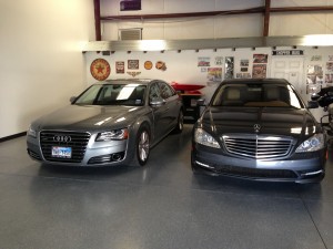 Picture of an Audi and Mercedes in a storage facility.