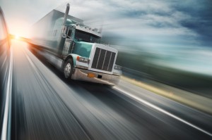 Picture: Auto transport carrier driving in motion on the freeway.